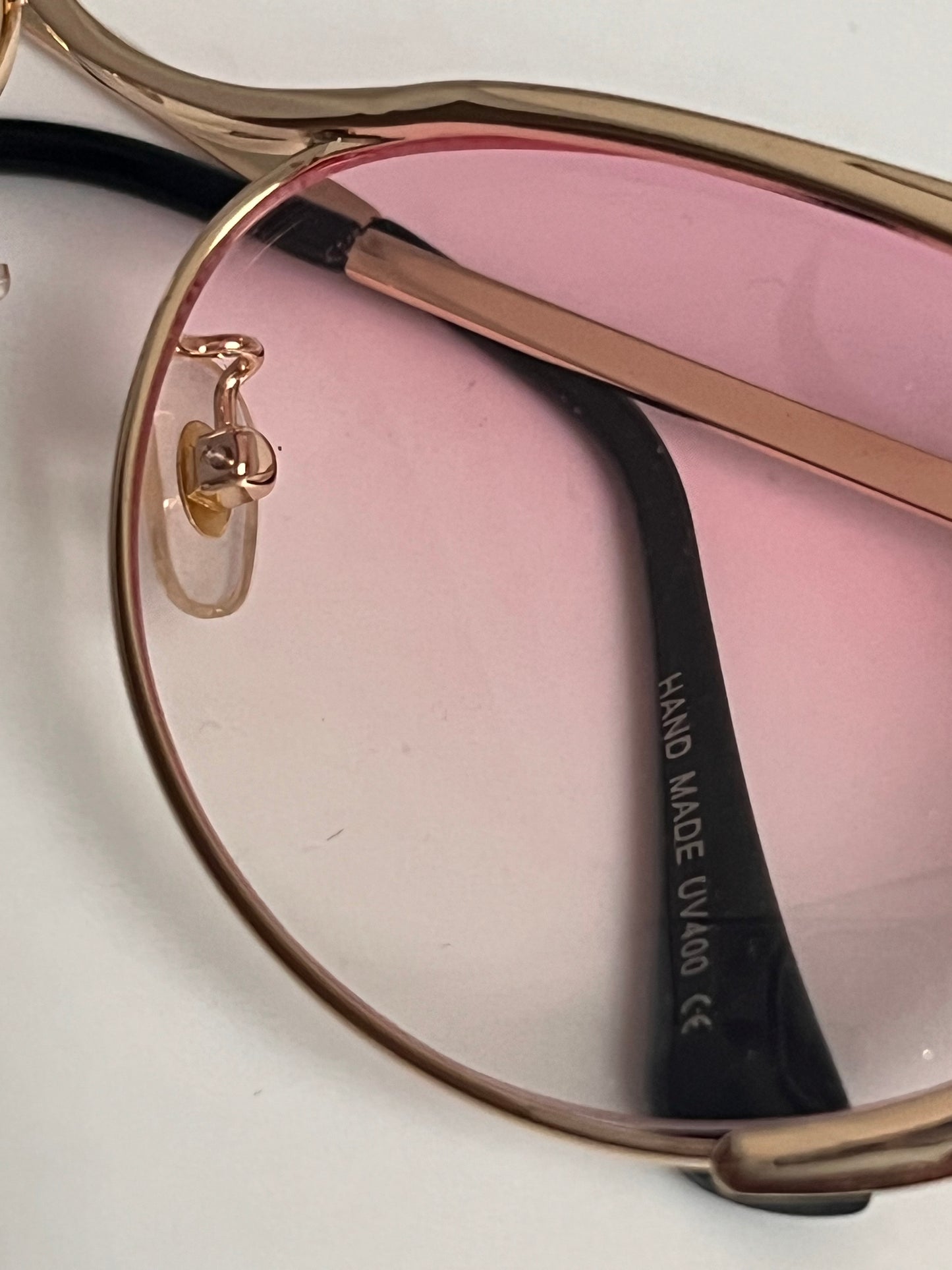 Solbriller Cat Eye gullfarget med rosa gjennomsiktig glass.