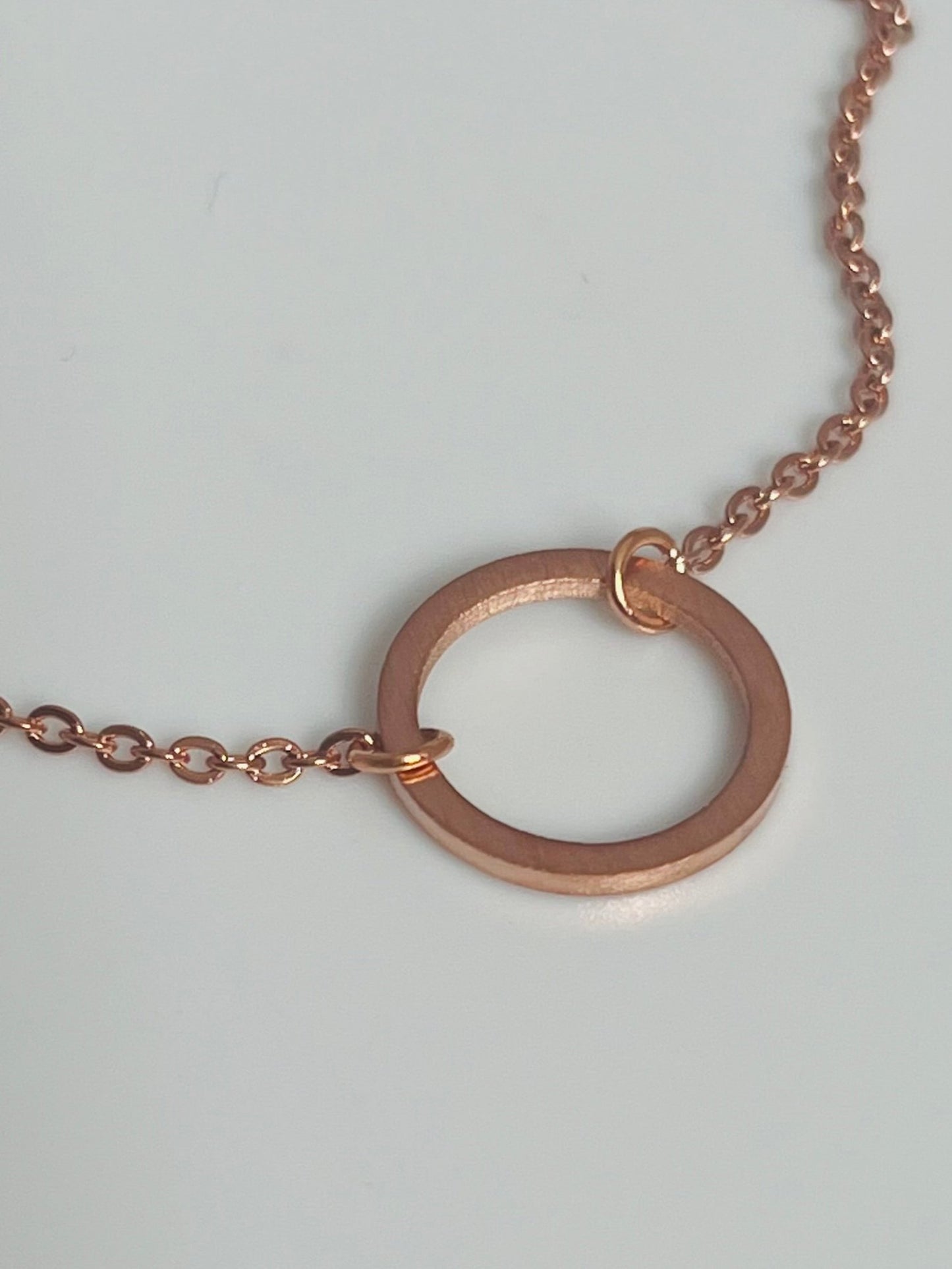 Rosegullfarget armbånd med rundt motiv.