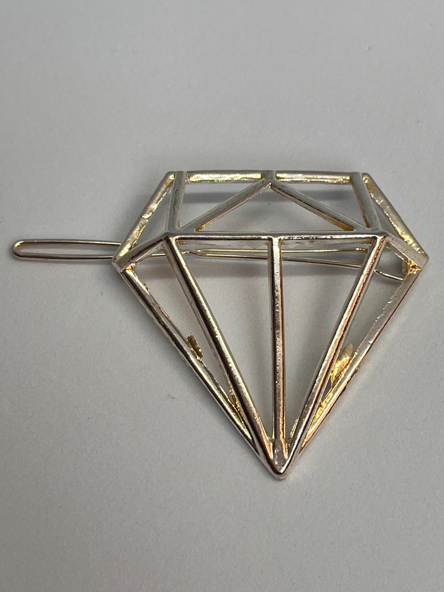 Hårspenne  Diamantformet sølvfarget.